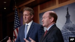 Sen. Jeff Flake, R-Ariz., left, and Sen. Chris Coons, D-Del., talk to reporters after making speeches on the Senate floor calling for a resolution to back the U.S. intelligence community findings that Russia interfered in the 2016 election and calling for other responses to the meddling, on Capitol Hill in Washington, July 19, 2018. 