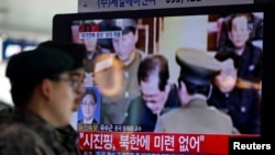 2013年12月13日在韩国首都首尔的火车站，韩国军人观看电视报道朝鲜处决张成泽的新闻。
