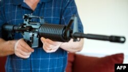 Seorang pria memegang senapan semi-otomatis Colt AR-15 di Manassas, Virginia, 4 Februari 2013.