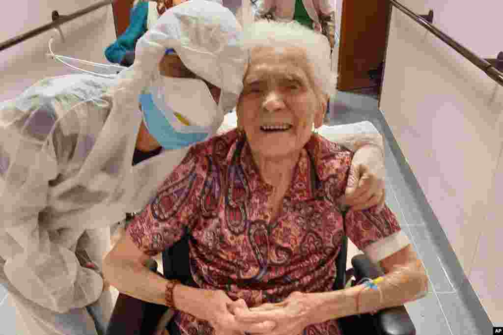 En esta foto tomada el 1 de abril de 2020, Ada Zanusso, de 103 años, posa con una enfermera en la casa de ancianos "Maria Grazia" en Lessona, en el norte de Italia, después de recuperarse tras el contagio con la COVID-19. Para recuperarse de la infección por coronavirus, Zanusso recomienda coraje y fe, las mismas cualidades que le han servido en más de un siglo de vida. El coronavirus ha demostrado ser especialmente letal en los adultos mayores y las personas con problemas de salud existentes.
