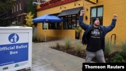 Un ciudadano celebra haber depositado su voto en un buzón para votación anticipada en en Portland, Oregon, el 3 de noviembre de 2020.