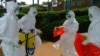 FILE - World Health Organization officials wear protective clothing as they prepare to enter Kagadi Hospital in Kibale District, about 200 kilometers from Kampala.