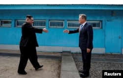 South Korean President Moon Jae-in and North Korean leader Kim Jong Un shake hands at the truce village of Panmunjom inside the demilitarized zone separating the two Koreas, South Korea.