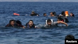 A refugee shouts as he swims towards the shore after a dinghy carrying Syrian and Afghan refugees deflated some 100m away before reaching the Greek island of Lesbos, September 13, 2015.