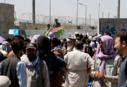 Kerumunan orang menunjukkan dokumen mereka kepada pasukan AS di luar bandara di Kabul, Afghanistan 26 Agustus 2021. (Foto: Reuters)