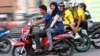 An Acehnese woman straddles on a motorbike on a road in Lhokseumawe, Aceh province, Indonesia, January 7, 2013.