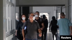 Lugareños usan máscaras dentro del hospital regional de Talca después de que se confirmara el primer caso de coronavirus en Chile en Talca, el 3 de marzo de 2020.