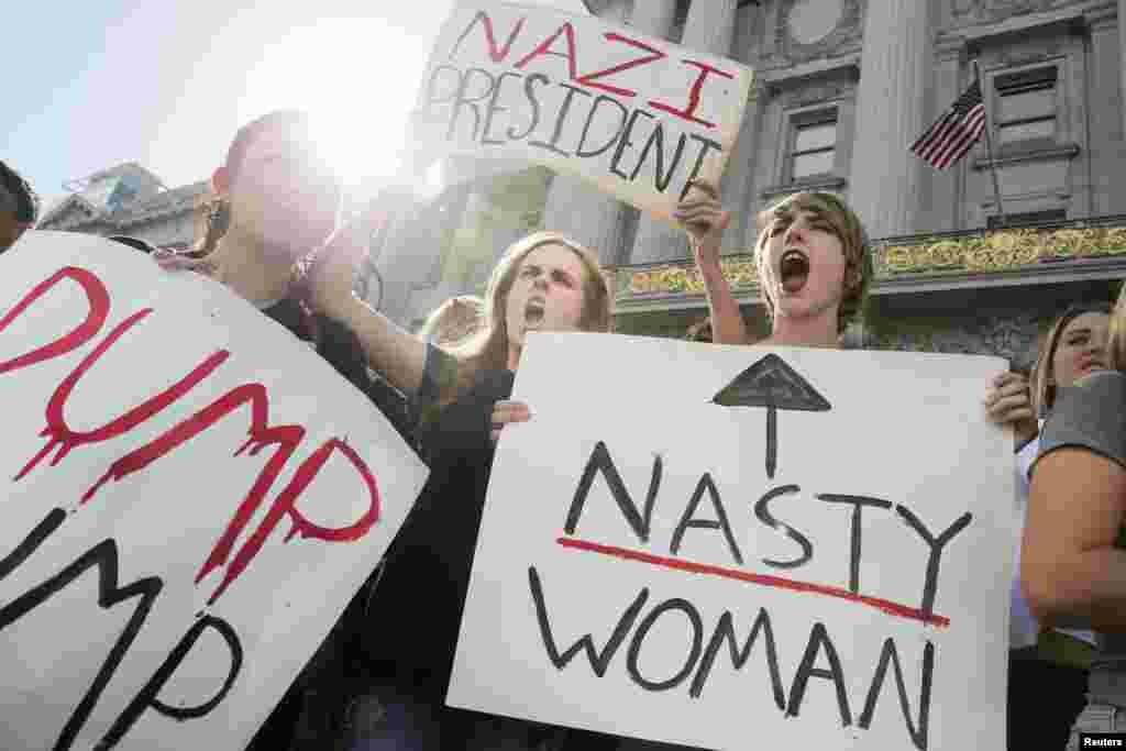 Hope Robertson (tengah) dan Cat Larson (kanan), keduanya berusia 17 tahun dan bersekolah di SMA Mission, San Francisco, California, berdemonstrasi di depan Balai Kota untuk memprotes pemilihan Donald Trump sebagai presiden AS (10/11). (Reuters/Elijah Nouvelage)