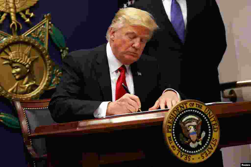 Donald Trump signe un décret pour durcir les contrôles pour les voyageurs de sept pays désirant se rendre aux Etats-Unis ainsi qu'une suspension de l'accueil des refugies pour 90 jours, Pentagone, Arlington, le 27 janvier 2017. Ces mesures seront annulées plusieurs fois par la justice américaine. 