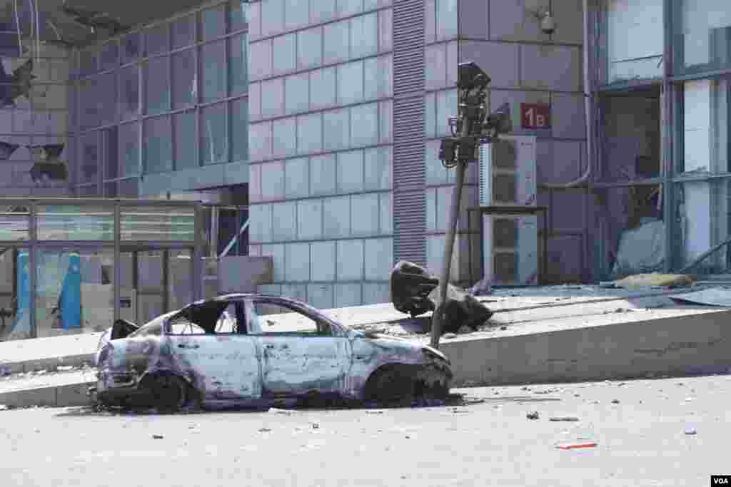 天津爆炸事故现场,核心爆炸区周围多座居民楼窗户被震碎,高速公路桥梁受损,多辆大货车被炸翻,小汽车起火或被砸,多名当地居民仍逗留在事故现场。(美国之音记者东方拍摄)