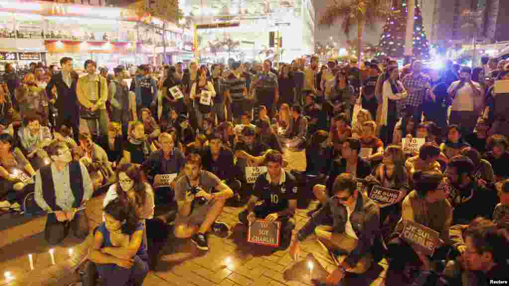Des gens participent à une veillée pour rendre hommage aux victimes d'une fusillade dans les bureaux Charlie Hebdo au Parc Kennedy à Lima, au Pérou, le 7 janvier 2015.