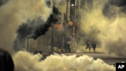 Demonstrators face police officers during clashes in Ettadhamen City near Tunis, Tunisia, Jan. 19, 2021. 