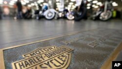 FILE - Rows of motorcycles are seen behind a bronze plate with corporate information on the showroom floor at a Harley-Davidson dealership in Glenshaw, Pennsylvania, April 26, 2017.