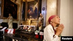 Une femme prie lors d'une messe en hommage aux victimes à la cathédrale de Nice, le 15 juillet 2016.