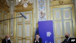 En esta foto de archivo del 12 de diciembre de 2020, el presidente francés Emmanuel Macron, centro, flanqueado por el canciller Jean-Yves Le Drian, izquierda, y el presidente del Consejo Constitucional, Laurent Fabius.