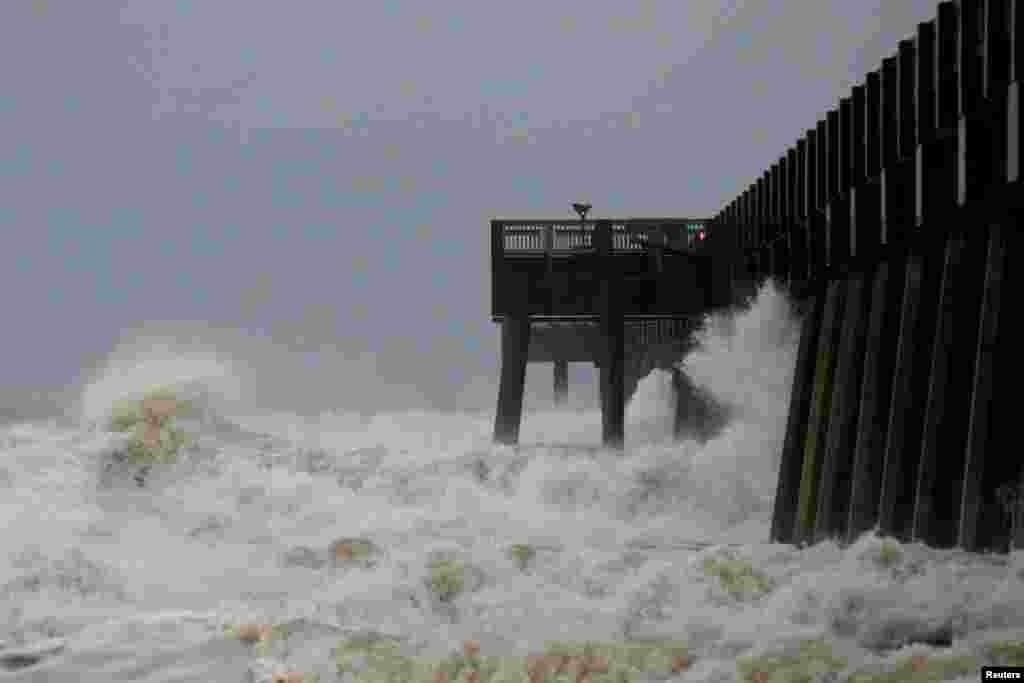 Waves crash along a pier as Hurricane Michael approaches Panama City Beach, Florida, Oct. 10, 2018.
