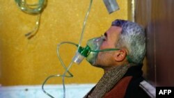 Seorang pria Suriah mengenakan masker oksigen di rumah sakit darurat setelah terjadinya apa yang diperkirakan serangan dengan menggunakan gas beracun di kota Douma sebuah kantong pemberontak yang terkepung di kawasan Ghoute timur di pinggiran Damaskus, 22 Januari 2018 (foto: AFP Photo/Hasan Mohamed)