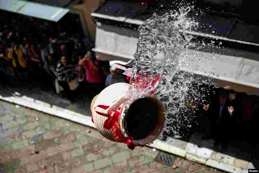 A clay pot full of water is thrown from a balcony during the Greek Orthodox Easter tradition of "Botides" on Holy Saturday marking the so-called "First Resurrection", on the island of Corfu, Greece, April 30, 2016.