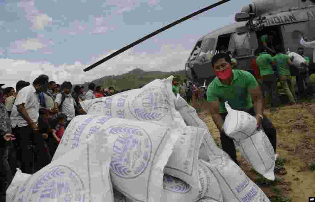 Nepalese volunteers unload relief material brought in an Indian air force helicopter for victims of Saturday’s earthquake at Trishuli Bazar in Nepal.