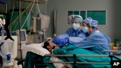Medical staff tend to a patient in the emergency COVID-19 ward at the San Carlo Hospital in Milan, Italy, April 16, 2020.