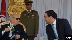 Le président tunisien Béji Caïd Essebsi, à gauche, et le Premier ministre Youssef Chahed assistent au forage militaire des forces navales tunisiennes, au port de La Goulette, à l'occasion du 62ème anniversaire de l'armée nationale, Tunis, le 25 juin 2018.