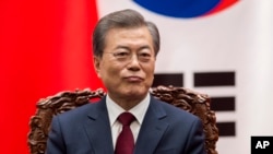 South Korean President Moon Jae-In sits next to Chinese President Xi Jinping (not seen) during a signing ceremony at the Great Hall of the People in Beijing, Dec. 14, 2017. 