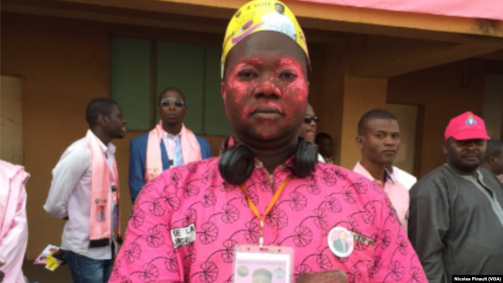 Un militant PNDS s'est peint le visage en rose pour soutenir Mahamadou Issoufou lors du meeting au stade Seyni Kountché de Niamey, 18 février 2016 (VOA/Nicolas Pinault)