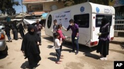 Petugas bantuan kemanusiaan mengukur suhu tubuh seorang warga di kota Kafr Takharim, provinsi Idlib, Suriah. (Foto: dok).
