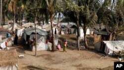 Muslim refugees stand near their tents in Awetawgyi refugee camp in Sittwe, Rakhine State, western Burma, January 8, 2013.