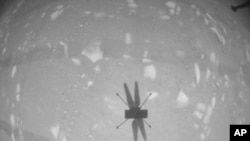 FLE - In this April 22, 2021, photo, made available by NASA, the Mars Ingenuity helicopter photographs its shadow with its black-and-white navigation camera during its second flight. 