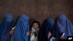 Sejumlah perempuan Afghanistan menunggu untuk menerima uang tunai oleh Program Pangan Dunia, di Kabul, Afghanistan, 20 November 2021. (Foto: AP/Petros Giannakouris)