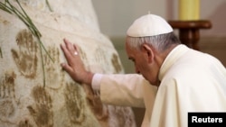 Pope Francis prays in front of the Virgin Mary statue at Caacupe church in Caacupe, outside of Asuncion, Paraguay, July 11, 2015. 