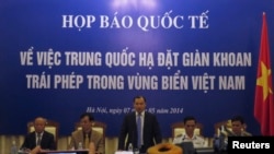 អ្នក​នាំ​ពាក្យ​របស់​វៀតណាម​ លោក Le Hai Binh (រូប​កណ្តាល) ថ្លែង​នៅ​ក្នុង​សន្និសីទ​កាសែត​មួយ​ស្តី​ពី​ការ​ដាក់​ពង្រាយ​ម៉ាស៊ីន​បូម​ប្រេង​ពី​ផ្នែក​នៃ​សមុទ្រ​ចិន​ខាង​ត្បូង​ដែល​មាន​ជម្លោះ នៅ​ក្នុង​ក្រុង​ហាណូយ កាលពី​ថ្ងៃទី៧ ខែឧសភា ឆ្នាំ២០១៤។