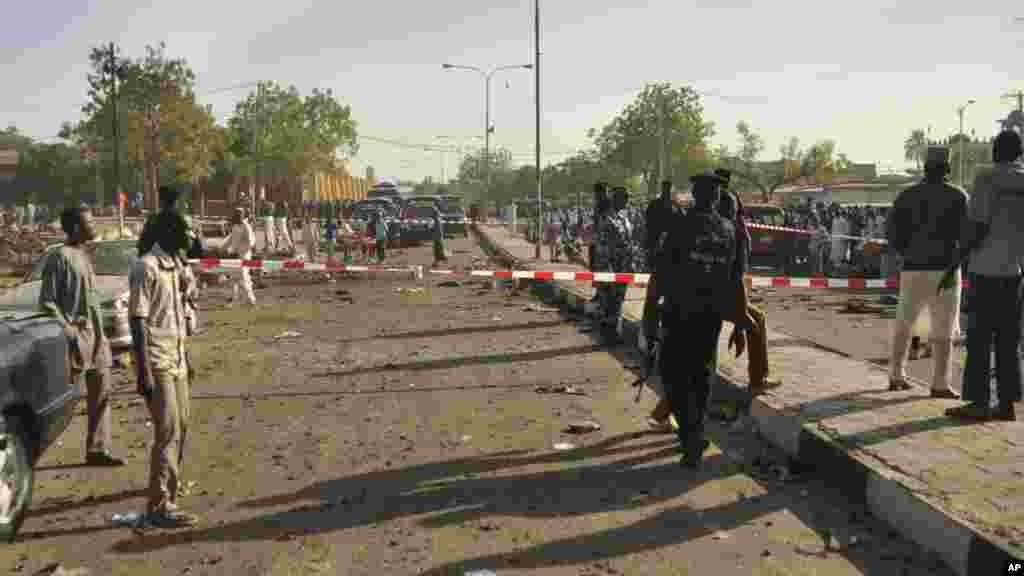 Mutane sun taru su na kallo a inda bam ya tashi a babban Masallacin Jumma'a na Kano, Jumma'a 28 Nuwamba, 2014. Mutane da yawa sun rasa rayukansu, kuma jami'ai suka ce watakila yawan wadanda zasu hallaka zai karu.