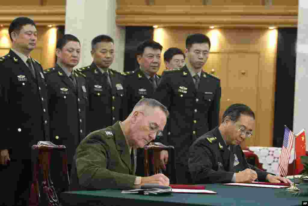 美军参联会主席邓福德上将(前左)与中国中央军委联合参谋部参谋长房峰辉在北京签署协议。 (2017年8月15日)