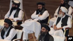 FILE - Taliban co-founder Abdul Ghani Baradar, bottom right, speaks during peace talks between the Afghan government and the Taliban in Doha, Qatar, Sept. 12, 2020.
