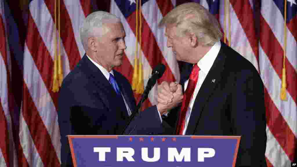 Le président élu Donald Trump se serre la main avec le vice-président élu Mike Pence au moment du discours d'acceptation au cours de la nuit électorale, à New York, 9 novembre 2016.