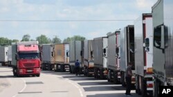 Країни Балтії Естонія, Латвія та Литва скоординовано заборонили в'їзд транспортних засобів з російськими номерними знаками на свою територію в рамках нещодавнього роз'яснення Європейським Союзом санкцій проти Росії. (Фото AP, архів - вантажівки на кордоні РФ та Литви)
