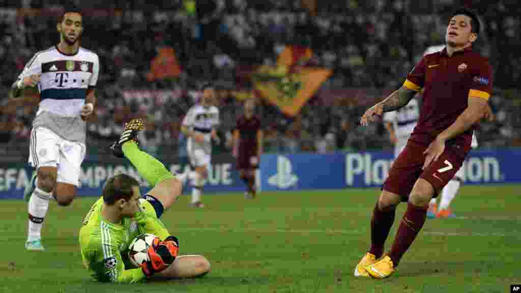 Le gardien de but du Bayern Manuel Neuer, à gauche, sauve la balle passé par Juan Manuel Arevalos Iturbe pendant le match de football du Groupe E de la Ligue des Champions entre Roma et le Bayern Munich au stade olympique, à Rome, le mardi 21 octobre, 2014.