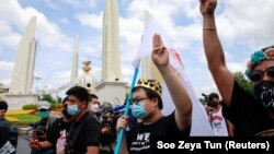 Pemimpin protes Parit "Penguin" Chiwarak (dengan mahkota) menunjukkan salut tiga jari selama demonstrasi untuk menandai peringatan 89 tahun penghapusan monarki absolut di Bangkok, Thailand, 24 Juni 2021. (Foto: REUTERS/Soe Zeya Tun)
