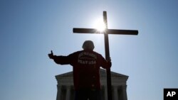Tom Alexander sostiene una cruz mientras reza antes de que la Corte Suprema de EE.UU. emitiera un fallo sobre excepción religiosa a empleadores en relación a la Ley de Cuidado Médico Asequible. Washington D.C., jMasooulio 8, 2020.
