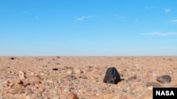 FILE - A small asteroid, 2008 TC3, fell to Earth at dawn on Oct. 7, 2008, tracking through the skies over the Nubian Desert in northern Sudan.