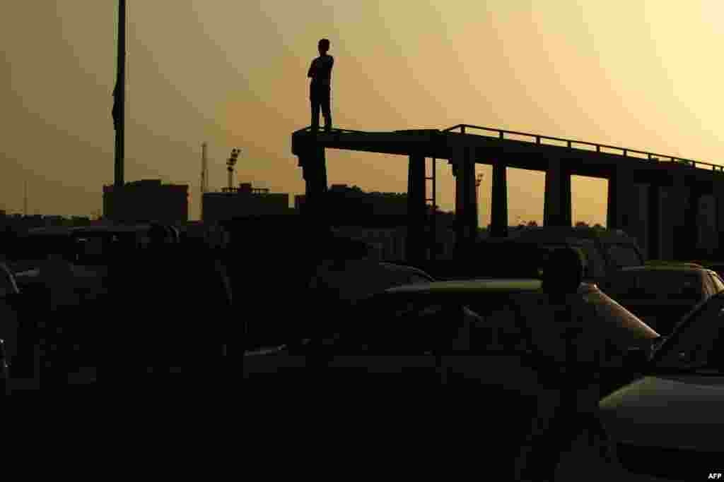 A silhouette of a Libyan man is seen during a protest against a new government proposed by U.N. envoy Bernardino Leon, in the eastern city of Benghazi. World leaders urged Libya's warring parties to sign a proposed peace deal installing a national unity government, after a cool response from some lawmakers in the country's rival parliaments.