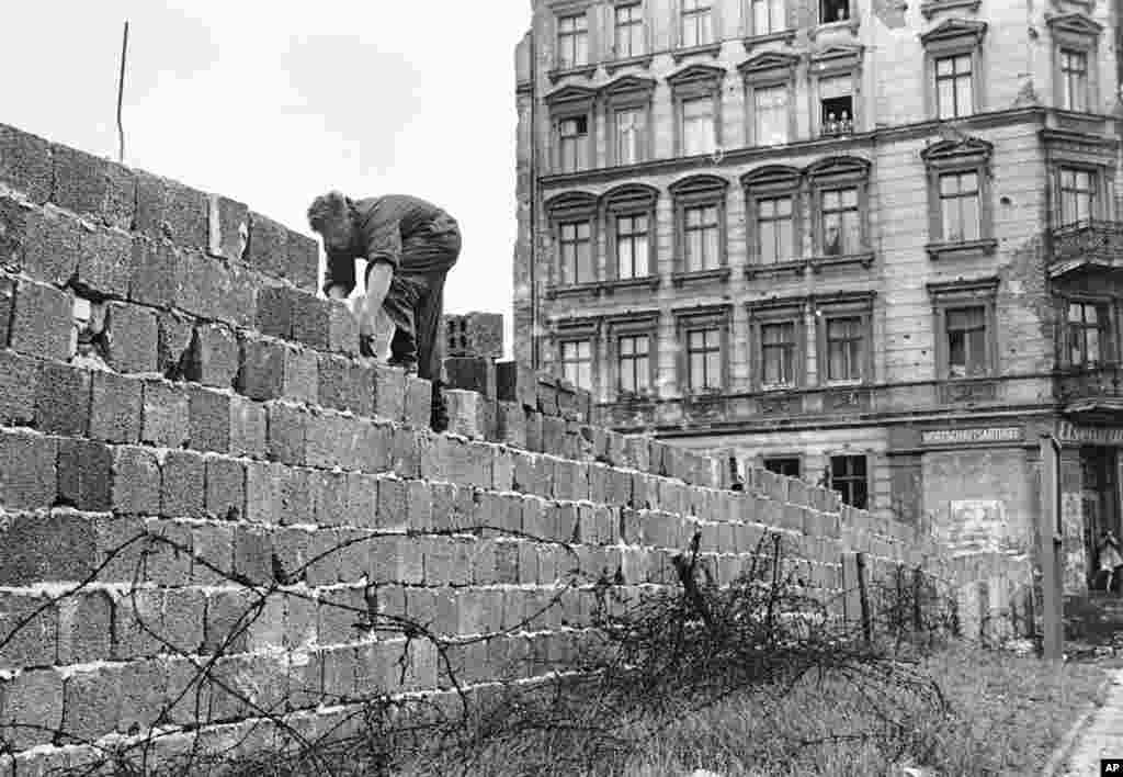 ARCHIV - Ein Ostberliner Polizist arbeitet am 9. Oktober 1961 an der Berliner Mauer. Am Donnerstag, den 13. August 2009, jaehrt sich der offizielle Tag des Mauerbaus zum 48. Mal. (AP Photo/Archiv) * NUR S/W * --- FILE - In this Oct. 9, 1961 file photo an