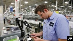 This 2014 photo shows Jonah Devorak testing the dimensions on a high-pressure valve at Swagelok Company in Strongsville, Ohio. Devorak was stuck in a “dead-end job” at a suburban Cleveland restaurant where he’d been washing dishes and manning the grill since he was 16. His outlook turned around after hearing about a program at Cuyahoga Community College that trains students for manufacturing jobs at a company that had openings for dozens of machine operators. (AP Photo/Tony Dejak)
