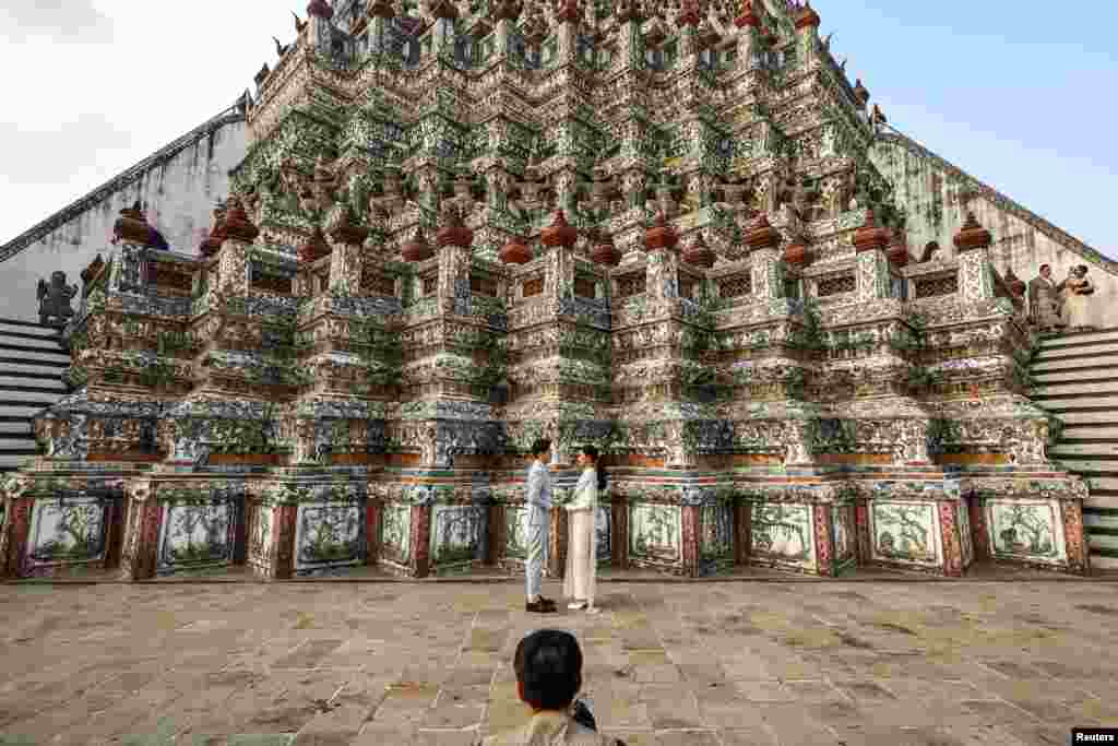 Otros esperan el día para hacer una romántica propuesta o para dar el gran "Sí". En Bangkok, Tailandia, una pareja de novios celebra su unión en el imponente Templo del Amanecer.