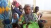 FILE - Refugees who fled their homes due to violence from the Islamic extremist group Boko Haram sit inside a refugee camp in Minawao, Cameroon, on Feb. 25, 2015. Tensions between host communities and displaced people in Cameroon have boiled over with killings and arson.