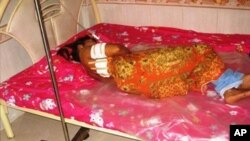 An unidentified garment worker lying on a hospital bed with multiple gunshot wounds to her back. The police identified the mayor of Bavet town, Chhouk Bandit, as the prime suspect.