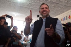 ARCHIVO - Roberto Arzu levanta su dedo manchado de tinta después de emitir su voto durante las elecciones generales en la Ciudad de Guatemala, el 16 de junio de 2019. Arzu perdió su apelación final para volver a la carrera presidencial de 2023 el jueves 25 de mayo de 2023. El electoral tribunal anuló su candidatura por supuestamente haber iniciado prematuramente su campaña. (Foto AP/Santiago Billy, archivo)