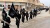 FILE - Fighters from the Islamic State group march in Raqqa, Syria, Jan. 14, 2014.
